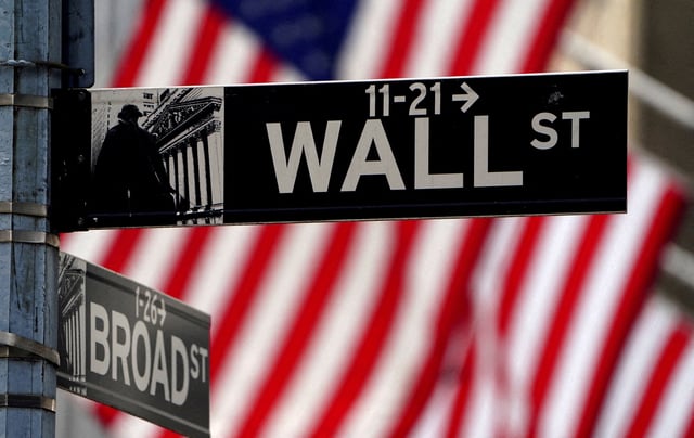 A Wall Street sign is pictured outside the New York Stock Exchange, New York City, U.S., April 16, 2021. REUTERS/Carlo Allegri/File Photo