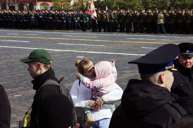 A woman hugs a child during the Victory Day military parade at Red Square in Moscow on May 9, 2024.