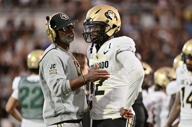 Colorado coach Deion Sanders and QB Shedeur Sanders talk during the second half of the Buffaloes' win over UCF.