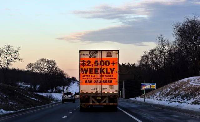 A tractor trailer advertising job opportunities in the trucking industry drives south on Interstate 81 near Staunton, Virginia, U.S., January 22, 2022. Picture taken January 22, 2022. REUTERS/Evelyn Hockstein/File Photo