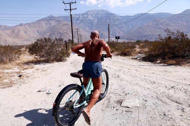 FILE: Daryl Luppino pushes off after taking a break during his bike ride on July 9, 2021, near Palm Springs, Calif.