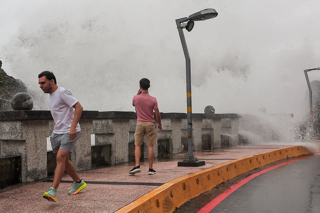 A person takes photos of the waves as Typhoon Krathon approaches in Kaohsiung, Taiwan October 2, 2024. REUTERS/Ann Wang
