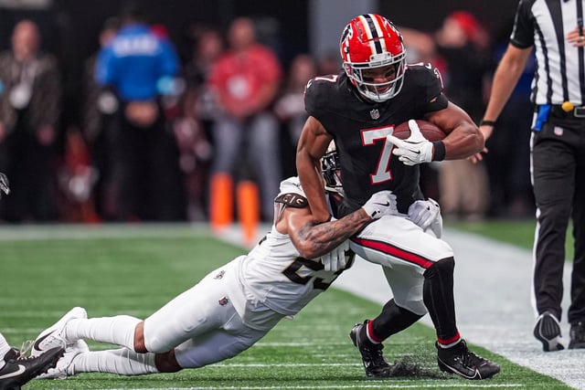 Sep 29, 2024; Atlanta, Georgia, USA; Atlanta Falcons running back Bijan Robinson (7) runs against New Orleans Saints cornerback Marshon Lattimore (23) during the first quarter at Mercedes-Benz Stadium. Mandatory Credit: Dale Zanine-Imagn Images