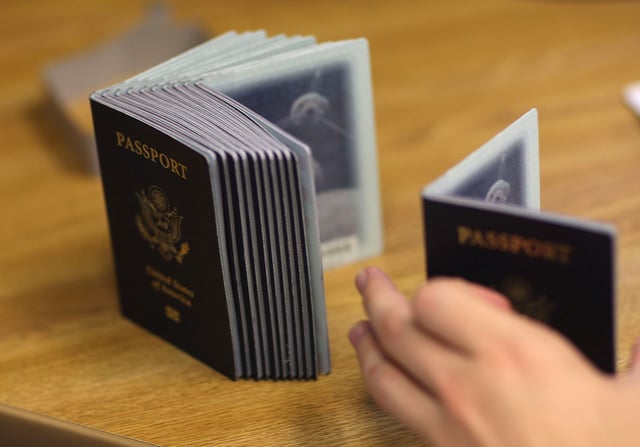 MIAMI - JUNE 22:  A Passport Processing employee uses a stack of blank passports to print a new one at the Miami Passport Agency June 22, 2007 in Miami, Florida. The Bush administration postponed for at least six months a requirement that Americans who return to the United States by land or sea from Canada, Mexico and the Caribbean must carry passports. The rule, due to go into effect in January 2008, will be delayed until the summer of that year.  (Photo by Joe Raedle/Getty Images)