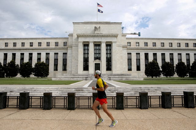 A jogger runs past the Federal Reserve building in Washington, DC, U.S., August 22, 2018. REUTERS/Chris Wattie/File Photo
