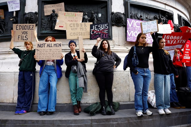Women hold signs reading 'Not all men, but always a man,' at a Sept. 14 demonstration in support of Gisèle Pelicot.