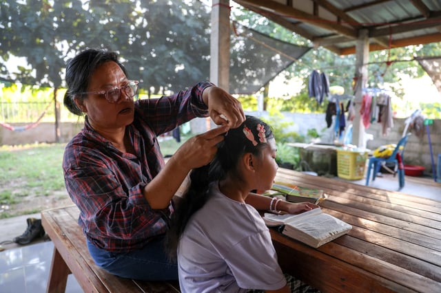 Wiwwaro Sriaoun, 53, spends time with Irada Sriaoun,9, a daughter of a remaining Thai hostage captured by Hamas, Watchara Sriaoun, at their house, in Kut Yang village, Udon Thani province, Thailand, October 6, 2024. REUTERS/Thomas Suen