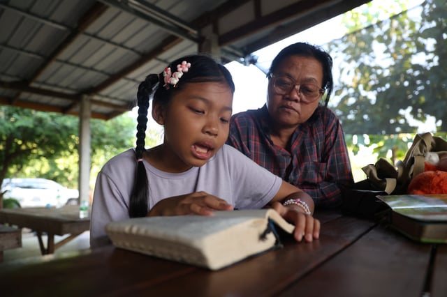 Wiwwaro Sriaoun, 53, teaches Irada Sriaoun,9, a daughter of a remaining Thai hostage captured by Hamas, Watchara Sriaoun, at their house, in Kut Yang village, Udon Thani province, Thailand, October 6, 2024. REUTERS/Thomas Suen