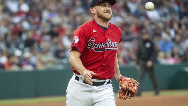 Cleveland Guardians starting pitcher Tanner Bibee tosses out Texas Rangers' Jonah Heim at first base during the third inning of a baseball game in Cleveland, Saturday, Sept. 16, 2023. (AP Photo/Phil Long)