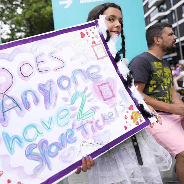 A fan of Taylor Swift holds a sign asking for tickets as she arrives at Wembley Stadium in London for the first of five concerts of Taylor Swift's Eras Tour, Thursday, Aug. 15, 2024. THE CANADIAN PRESS/AP-Alastair Grant