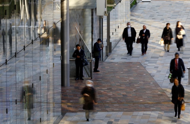 A man uses a laptop on a street at a business district in Tokyo, Japan January 23, 2024. REUTERS/Kim Kyung-Hoon/ File Photo