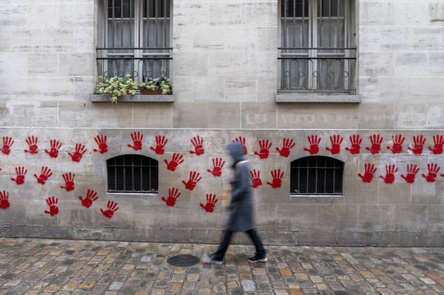 Le mur d'enceinte du Mémorial de la Shoah recouvert de tags représentants des mains rouges à Paris, le 14 mai 2024.