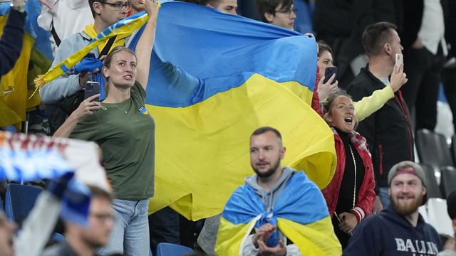 Ukraine fans wave a flag after the UEFA Champions League Group H soccer match between Shakhtar Donetsk and FC Porto in Hamburg, Germany, Tuesday, Sept. 19, 2023. (AP Photo/Martin Meissner)