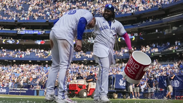 Toronto Blue Jays' Matt Chapman, left, is doused by teammate Vladimir Guerrero Jr., right, after hitting a walkoff double against the Boston Red Sox in baseball game action in Toronto, Sunday, Sept. 17, 2023. (Andrew Lahodynskyj/The Canadian Press via AP)