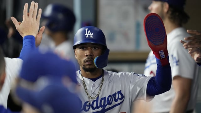 Los Angeles Dodgers' Mookie Betts celebrates in the dugout after scoring off of a double hit by designated hitter J.D. Martinez during the third inning of a baseball game against the San Francisco Giants in Los Angeles, Saturday, Sept. 23, 2023. Max Muncy also scored. (AP Photo/Ashley Landis)