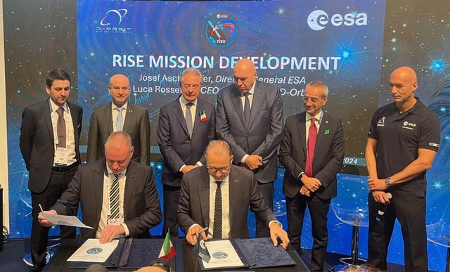 Seated, left to right, are D-Orbit CEO Luca Rossettini and ESA Director General Josef Aschbacher signing an agreement for Europe's first life extension mission for a satellite in geostationary orbit.