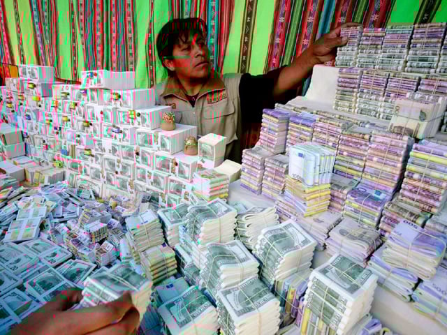 A stallholder sells fake bills, traditionally purchased for good fortune, at the traditional "Alasitas" fair in La Paz January 24, 2010.
