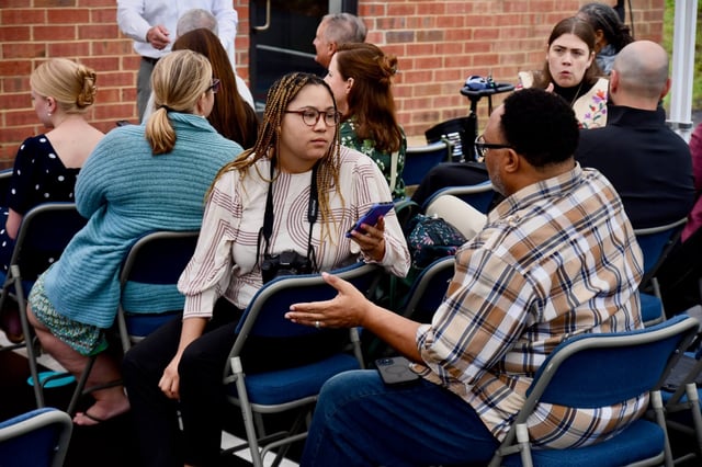 Qcity Metro reporter Destiniee Jaram interviews a subject at an event marking the opening of a small business hub in one of Charlotte, N.C.'s historically Black communities. (Credit: Qcity Metro)