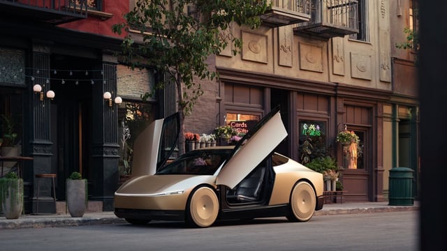 Early designs suggest the robotaxi is likely to be a two-door sedan with “scissor doors” that swing upwards to open, with no steering wheel or pedal