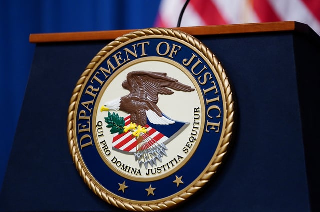 The seal of the U.S. Justice Department is seen on the podium in the Department's headquarters briefing room before a news conference with the Attorney General in Washington, January 24, 2023.  REUTERS/Kevin Lamarque/File Photo