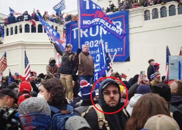 Jeffrey Newcomb at the Capitol on Jan. 6, 2021, with a banner in the background brought by him.