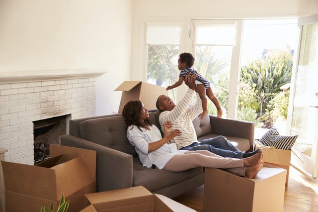 A young family is seen moving into their new home.
