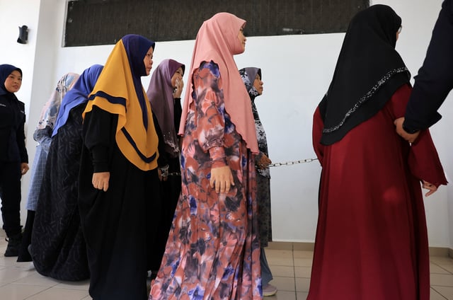The members of Global Ikhwan Services and Business Holdings (GISB) walk at Selayang court, as they face charges at the court, in Selayang, Malaysia October 23, 2024. REUTERS/Hasnoor Hussain