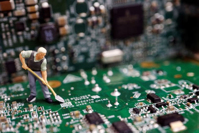 A worker miniature is placed among printed circuit boards with semiconductor chips, in this illustration picture taken July 5, 2023. REUTERS/Florence Lo/Illustration/ File Photo