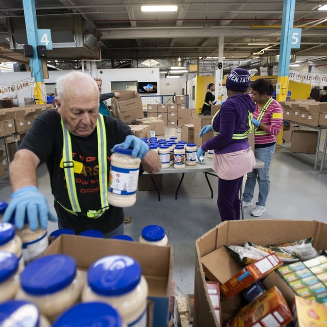 Volunteers sorting and boxing food at the Daily Bread Food Bank, are photographed on April 18, 2023. (Fred Lum/The Globe and Mail)