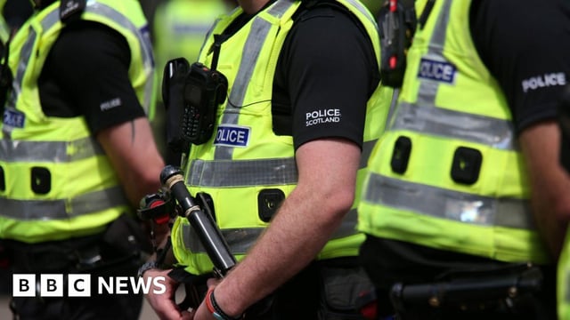 Three police officers in high-viz vests and equipped with walkie-talkies - their heads are not visible