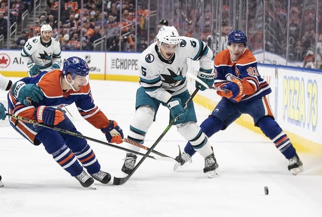 San Jose Sharks' Matt Benning (5) battles for the puck with Edmonton Oilers' Zach Hyman (18) and Ryan Nugent-Hopkins (93) during second period NHL action in Edmonton on Thursday April 13, 2023. The Toronto Maple Leafs have dealt defenceman Timothy Liljegren to the San Jose Sharks for defenceman Matt Benning, a third-round draft pick in 2025 and a sixth-round pick in 2026.THE CANADIAN PRESS/Jason Franson