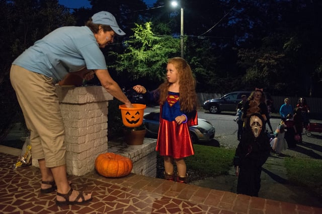 Trick-or-treaters make the rounds after sunset in Fayetteville, North Carolina, on Halloween night in 2016.