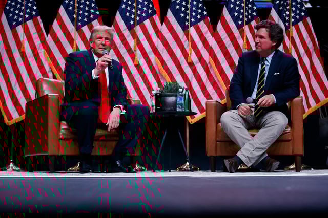 Former President Donald Trump sits down with Tucker Carlson during his Live Tour at the Desert Diamond Arena on October 31, 2024, in Phoenix, Arizona.