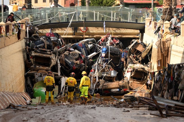 Members of a fire brigade search and rescue unit work as cars and debris block a tunnel after flash flooding in the Benetusser municipality of Valencia, Spain.