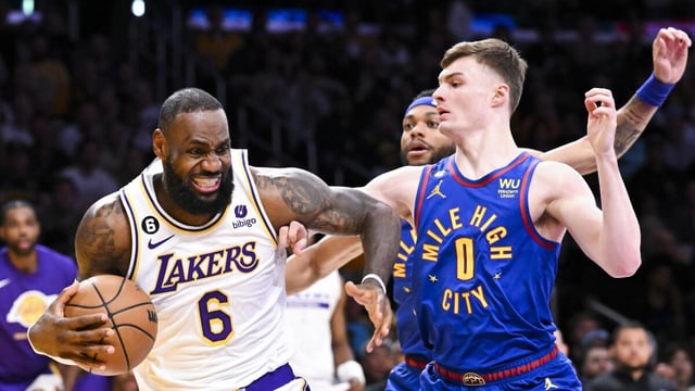 Lakers forward LeBron James winces as he drives to the basket in front of Nuggets guard Christian Braun 