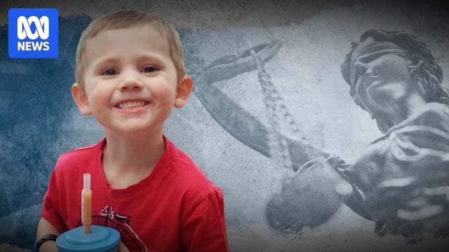 William Tyrrell smiling holding a cup with Lady Justice behind