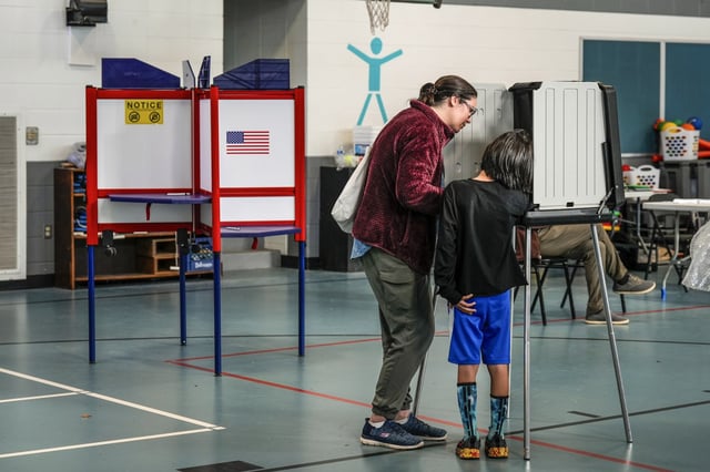Kristen Matson votes with her son at Lucy S. Herring Elementary School on Election Day, Tuesday, Nov. 5, 2024, in Asheville, N.C.