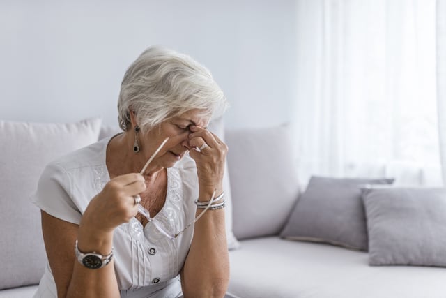 Older woman with a headache at home