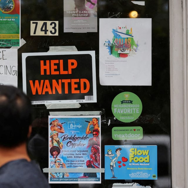 FILE PHOTO: A pedestrian passes a "Help Wanted" sign in the door of a hardware store in Cambridge, Massachusetts, U.S., July 8, 2022. REUTERS/Brian Snyder/File Photo