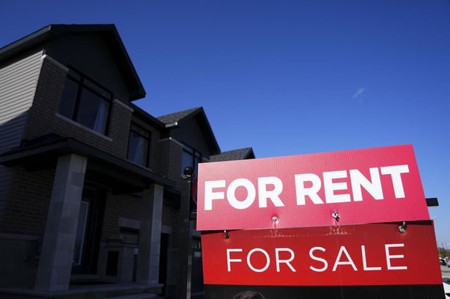 For rent and for sale signs are displayed on a house in a new housing development in Ottawa on Friday, Oct. 14, 2022. 