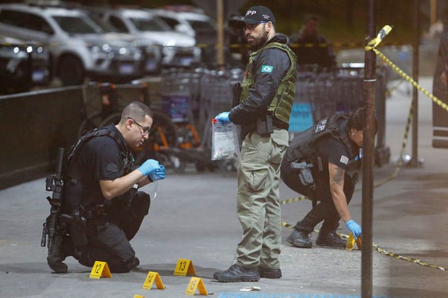 Police officers and forensic workers collect evidence at the scene of a shooting at Guarulhos international airport in Guarulhos, Sao Paulo on November 8, 2024. Brazilian real estate agent Antonio Vinicius Lopes Gritzbach, linked to organized crime, was shot dead Friday afternoon at Guarulhos international airport, which serves the city of Sao Paulo according to the Sao Paulo Public Security Secretariat. (Photo by Miguel SCHINCARIOL / AFP) (Photo by MIGUEL SCHINCARIOL/AFP via Getty Images)