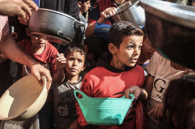 Des enfants palestiniens collectent de l’aide alimentaire dans le camp de réfugiés de Bureij, dans le centre de la bande de Gaza, le 6 novembre 2024.