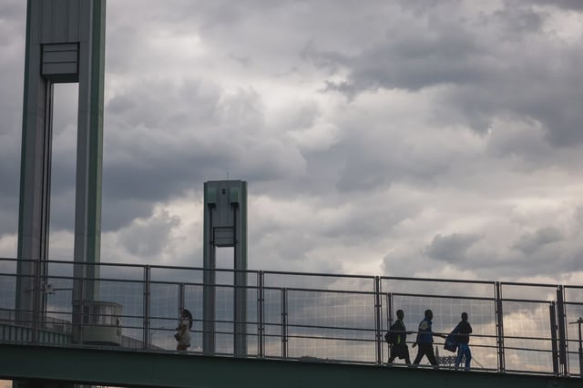 Recently arrived migrants cross a walking bridge into and out of Manhattan on Randall's Island.