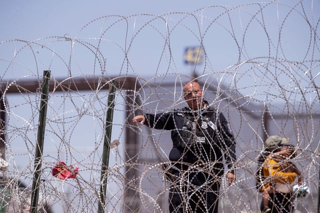 A U.S. Customs and Border Protection officer tells migrants to return to Mexico after migrants were attempting to reach U.S. soil in El Paso, Texas in order to seek asylum.