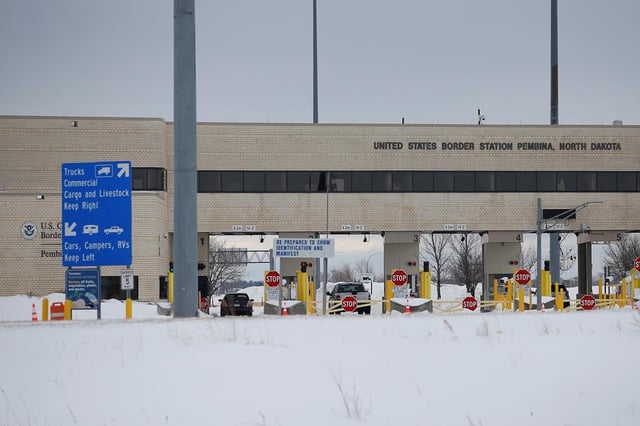 A lone car enters the US as people block highway 75 with heavy trucks and farm equipment and access to the Canada/US border crossing at Emerson, Man., Thursday, Feb. 10, 2022. The prosecution is expecting to wrap up its case today in the trial of two men accused of human smuggling at the border between Manitoba and Minnesota. THE CANADIAN PRESS/John Woods