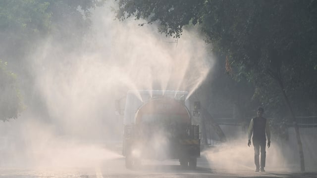 A tanker sprays water on roads to settle air pollution in Noida, which neighbours Delhi. 