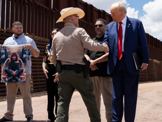 SIERRA VISTA, ARIZONA - AUGUST 22: Cochise County Sheriff Mark Dannels shakes hands with U.S. Republican Presidential Candidate and former President Donald Trump at the U.S.-Mexico border fence on August 22, 2024 south of Sierra Vista, Arizona. Republican Presdiential Candidate and former President Donald Trump will hold a rally in Glendale, Arizona tomorrow. (Rebecca Noble/Getty)
