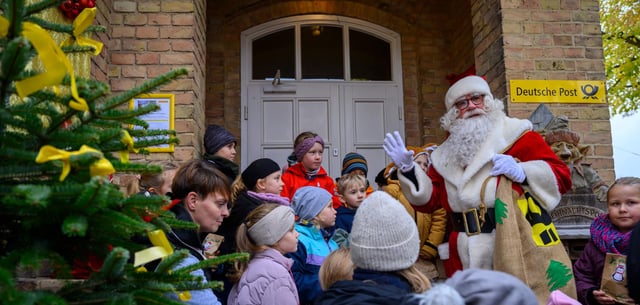 Weihnachtsmann steht am 14.11. mit Kindern vor dem Weihnachtspostamt