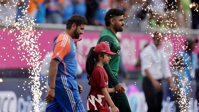 Pakistan's captain Babar Azam, right, and India's captain Rohit Sharma walk into the field 