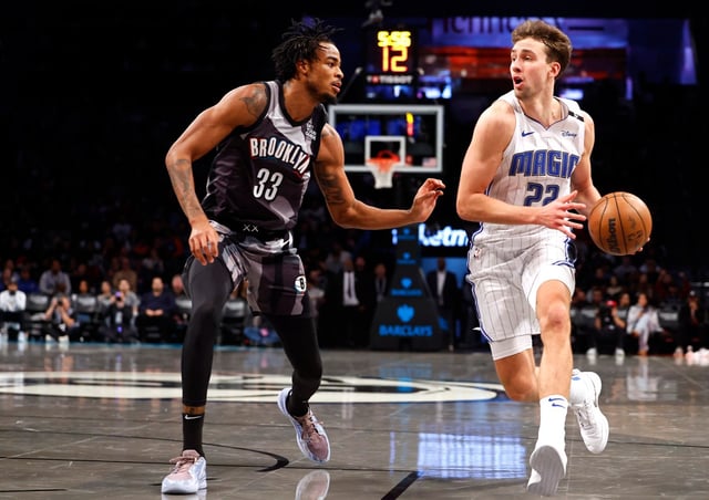 Orlando Magic forward Franz Wagner (22) drives to the basket against Brooklyn Nets center Nic Claxton (33) during the second half of an NBA basketball game, Sunday, Dec. 1, 2024, in New York. (AP Photo/Noah K. Murray)